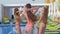 Company of amazing women with sexy body into bathing suit dancing near swimming-pool at resort during summer vacation