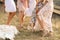 The company of female friends having fun, dancing on summerfield in long dresses showing their legs. Summer rural style picnic