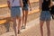 A company of girls walks the streets on a sunny summer day. Summer clothes