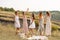 The company of gorgeous female friends having fun and enjoys a summer green hlls picnic, dancing and drink alcohol. People concept