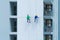 A company group of people, workers or painters, painting a wall on a high rise office building with cable wires outside in Bangkok