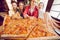 The company of guys in the pizzeria. Four friends in a cafe on the background of a large pizza on a wooden board.