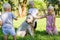 Company of kids playing with a dog in the park