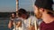 A company of young and cute friends enjoys a yacht ride during the day