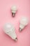 Comparison of different light bulbs on pink background. Vertical photo