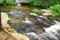 Comparison photo of similar image of stream rushing through a rocky bed, this image shot at high shutter speed.