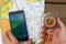 Compas in hand, maps and phone showing its screen with Pokemon Go application.