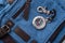 Compass and blue travel backpack, tourist items close-up, magnetic compass with metal clasp