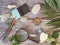 Compass, magnifier, notepad, pencil, sea stones on a textural wooden table