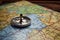 Compass on a map of the world. Selective focus, Magnetic compass and location marking with a pin on routes on world map, AI