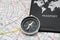 compass next to a passport on an urban map