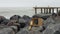 Compass and telescope spyglass on granite rocks. Metall pier, bollard and bitt