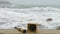 Compass and telescope spyglass on sand. Sunken barge, bollard and bitt