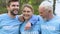 Competent group of eco volunteers hugging and smiling in park, green future