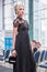 Competition hairdressers-stylists. A model in a long black dress presents the result of the work of a hair stylist on