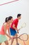 Competitive Chinese woman holding the racquet during a squash game