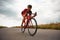 Competitive and concentrated man, triathlete riding bicycle on road outdoors, training for marathon