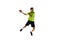 Competitive young guy in uniform, handball player in a jump, throwing ball during game against white studio background