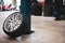 a complete wheel leans against a pillar in a car repair shop