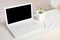 Completely white modern workspace with laptop, notepad, plant and pen