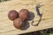 Complex-T Boilies with fishing hook. Fishing rig for carps, boilie rig, near the lake on a piece of wood