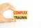 Complex trauma symbol. Concept words Complex trauma on wooden block. Beautiful white table white background. Doctor hand. Business