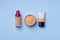 Complexion make up products and brush on blue background