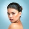 The complexion of perfection. Studio shot of an attractive young woman with a perfect complexion posing against a blue