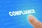 Compliance Regulations Computer Words with Finger Closeup