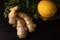 Components of Asian cuisine, healthy food. Ginger close-up and on a background of lemon on a wooden board and a dark background