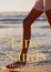 Composite of fine sands artemis kelly text over legs of caucasian woman in beach