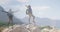 Composite of happy african american man hiking, and raising arms on mountainside