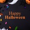 Composite of happy halloween text and halloween decorations on black background
