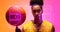 Composite of illuminated basketball court over portrait of serious biracial male player with ball