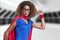 Composite image of african american woman in superhero costume against empty office in background