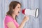 Composite image of angry woman with megaphone