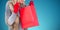 Composite image of blonde in winter clothes looking in shopping bag