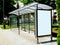 Composite image of bus shelter with blank poster ad and billboard lightbox panel