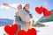 Composite image of carefree couple hugging on the beach in warm clothing