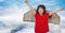 Composite image of caucasian boy in airplane costume against blue sky over winter landscape