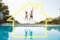 Composite image of cheerful couple jumping into swimming pool