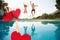 Composite image of cheerful couple jumping into swimming pool