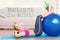 A Composite image of cheerful fit blonde doing sit ups with exercise ball