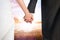 Composite image of close up of cute young newlyweds holding their hands