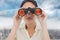 Composite image of closeup of a businesswoman looking through binoculars