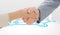 Composite image of closeup of shaking hands after business meeting