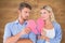 Composite image of couple holding two halves of broken heart