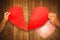 Composite image of cropped couple hands holding red cracked heart shape