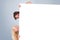 Composite image of cute couple hiding behind a whiteboard