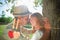 Composite image of cute smiling couple leaning against tree in the park